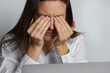 Tired woman suffering from eyes pain after working on the computer. Woman touching painful eyes