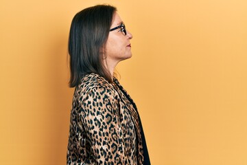 Poster - Middle age hispanic woman wearing business clothes and glasses looking to side, relax profile pose with natural face with confident smile.