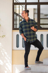 man having fun using mobile phone while standing outdoors on staircase