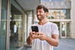 © Krakenimages.com - Young hispanic man smiling confident using smartphone at street