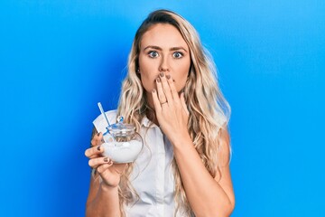 Sticker - Beautiful young blonde woman holding bowl with sugar covering mouth with hand, shocked and afraid for mistake. surprised expression