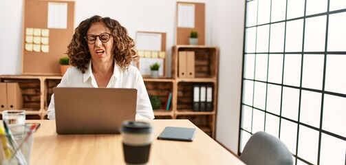 Sticker - Middle age hispanic woman working at the office wearing glasses with hand on stomach because indigestion, painful illness feeling unwell. ache concept.