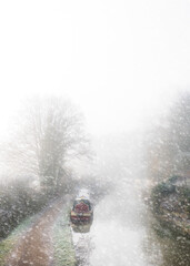 Sticker - Vertical shot of a canal boat at Thrupp amidst a flurry of snow on a winter day in rural Oxfordshire