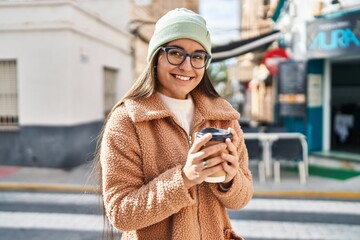 Poster - Young hispanic woman smiling confident drinking coffee at street