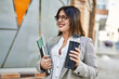© Krakenimages.com - Young hispanic businesswoman smiling happy holding bottle of water at the city.
