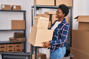 African american woman ecommerce business worker holding packages at office