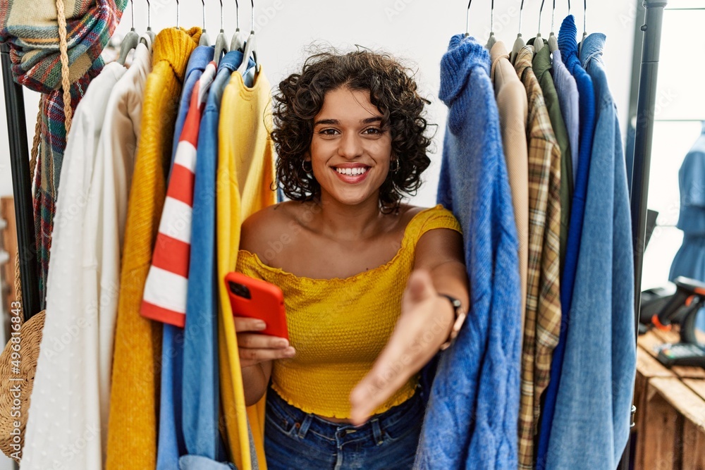 Hispanic Rack Young hispanic woman searching clothes on clothing rack using ...