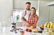 © Krakenimages.com - Young couple smiling confident making smoothie hugging each other at kitchen