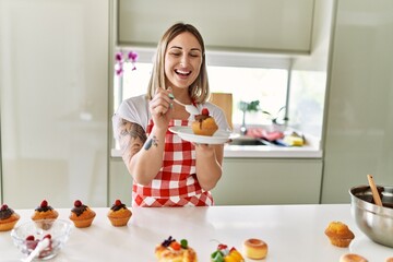 Wall Mural - Young caucasian girl smiling happy cooking pumpkins at the kitchen.