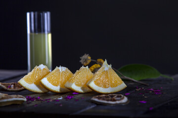 Wall Mural - Closeup shot of the orange fruit with juice in the background on a wooden table