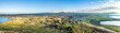 © AmazingAerialAgency - Panoramic aerial view of wind turbine farm in a grassland, a lake and mountain covered with snow in background, Golan Heights, Israel.