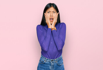 Sticker - Beautiful young asian woman wearing casual clothes afraid and shocked, surprise and amazed expression with hands on face