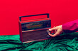© master1305 - Retro radio. Female hand touching radioreceiver isolated on red and green background. Vintage, retro fashion style. Pop art photography.