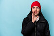 © Asier - Young caucasian woman isolated on blue background is saying a secret hot braking news and looking aside