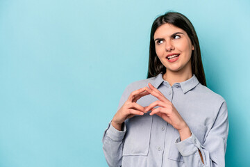 Wall Mural - Young caucasian woman isolated on blue background making up plan in mind, setting up an idea.