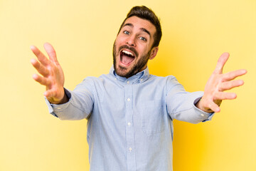Young caucasian man isolated on yellow background feels confident giving a hug to the camera.