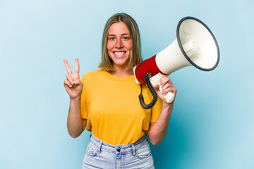 young caucasian woman holding a megaphone isolated on blue background showing number two with finger