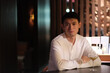 © Robert - portrait of one handsome Asian young man sitting at bar table, looking at camera at night