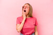 © Asier - Young caucasian woman isolated on pink background yawning showing a tired gesture covering mouth with hand.