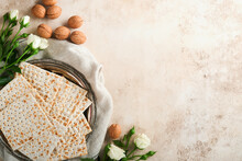 Passover Celebration Concept. Matzah, Red Kosher Walnut And Spring Beautiful Rose Flowers.. Traditional Ritual Jewish Bread On Sand Color Old Concrete Background. Passover Food. Pesach Jewish Holiday.