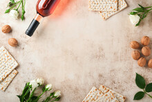 Passover Celebration Concept. Matzah, Red Kosher Walnut And Spring Beautiful Rose Flowers.. Traditional Ritual Jewish Bread On Sand Color Old Concrete Background. Passover Food. Pesach Jewish Holiday.
