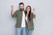 © deagreez - Photo of young two cheerful people celebrate success fists hands triumph isolated over grey color background