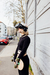 Wall Mural - Young nonconformist skater woman no makeup outdoor posing using 3D goggles