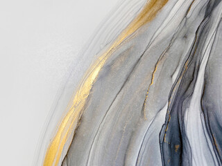 Abstract grey art with gold — black and white background with beautiful smudges and stains made with alcohol ink and golden paint. Grey fluid texture resembles marble, smoke, watercolor or aquarelle.
