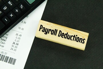 calculators, receipts and wooden boards with the word payroll deductions