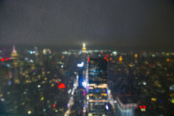 Wall Mural - Travel to New York. Manhattan from above viewed through a window with rain drops on it and blurry out of focus background. Inspirational mood photo.