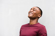 © mimagephotos - Close up happy young African American man laughing by gray background