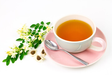 Moringa Tea in ceramic cup with fresh green leaf and flower isolated on white background. Moringa oleifera tropical herb healthy lifestyle concept.