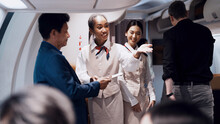 Cheerful Black Fight Attendant And Cabin Crew Assistant Checking Travel Tickets And Informing Seat To Passengers Before Departure Taking Care Of Passengers On Airplane Working With Service Mind       