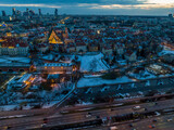 Fototapeta Miasto - Widok na zamek królewki i stare miasto w Warszawie z drona, w tle wieżowce, zaśnieżone dachy, zachód słońca
