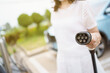 © DG PhotoStock - Unrecognizable Asian woman holding AC type 2 EV charging connector at EV charging station.