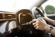 © DG PhotoStock - Unrecognizable female driver using left hand grabs on the steering wheel while driving on the road.