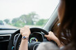 © DG PhotoStock - Unrecognizable female driver using left hand grabs on the steering wheel while driving on the road.