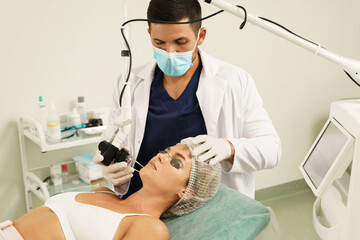 Poster - Doctor dermatologist and woman client during laser skin resurfacing treatment