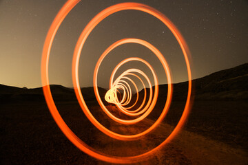 Wall Mural - red and spiral light painting in the starry night. long exposure photography.