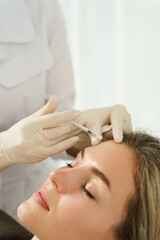 Wall Mural - Woman during facial filler injections in aesthetic medical clinic