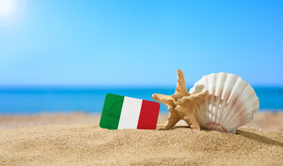 tropical beach with seashells and italy flag. the concept of a paradise vacation on the beaches of i