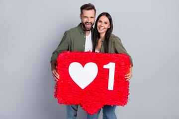 Poster - Portrait of attractive cheerful couple holding big red board like review isolated over grey pastel color background