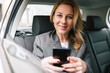 © bugarskipavle3 - A young business woman uses her phone in a car.