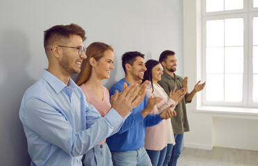 Happy diverse businesspeople applaud thank presenter for meeting or speech. Smiling employees or young people clap hands show acknowledgement and respect. Team greeting or congratulating.