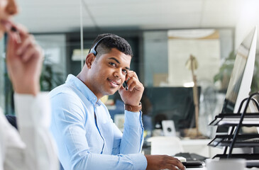 Wall Mural - always ready to assist. shot of a young call centre agent sitting in the office with a colleague and