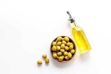 Wall Mural - Bottle of olive cooking oil with green olives in bowl