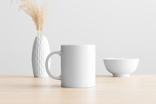 White Mug Mockup With A Dry Flower Decoration On The Wooden Table.