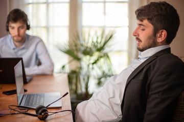 Sticker - jeune homme d'affaires ou employé de bureau fatigué à la fin de la journée qui se détend sur sa chaise devant son ordinateur. Il en a marre du travail