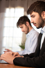 Wall Mural - deux jeunes employés de bureau ou hommes d'affaires travaillent ensemble avec des ordinateurs portables.