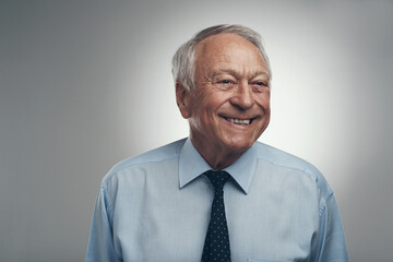 Wall Mural - Happiness is never something that goes out of style. Shot of a senior businessman standing alone against a grey background in the studio during the day.